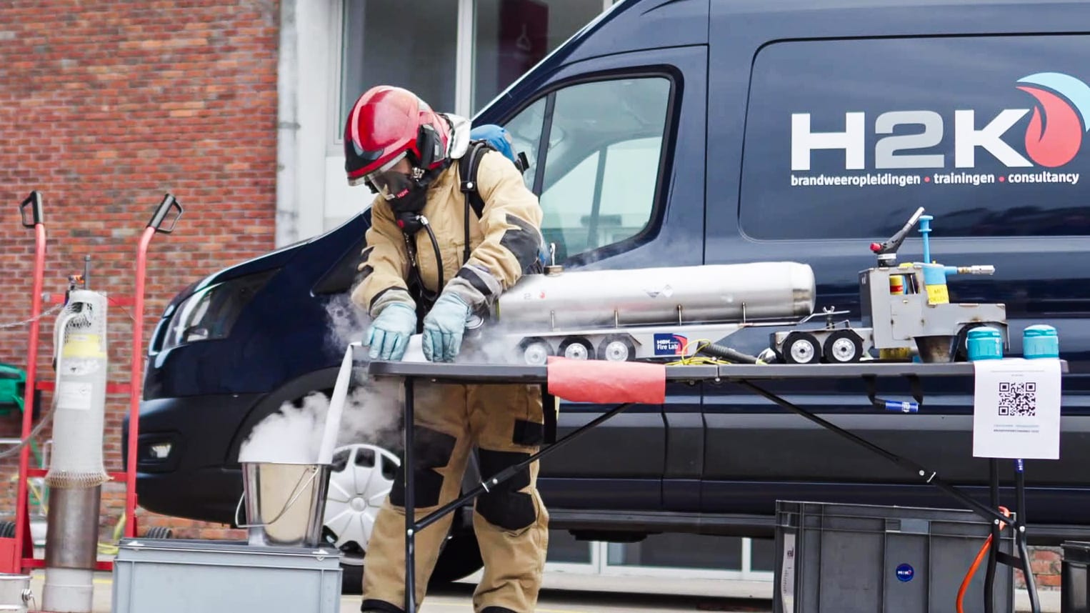 Brandweerman in ademlucht werkt aan een demo-opstelling voor de opleidingswagen van H2K