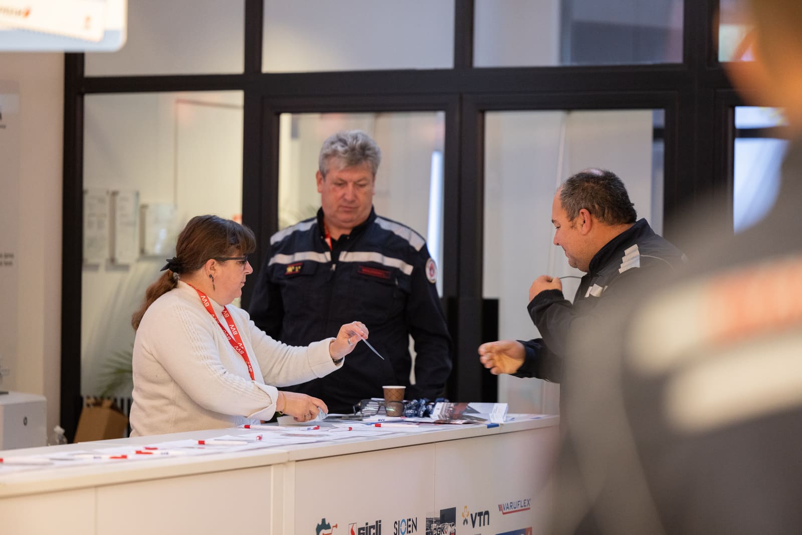 Deelnemer ontvangt zijn badge aan de onthaalbalie van het congres
