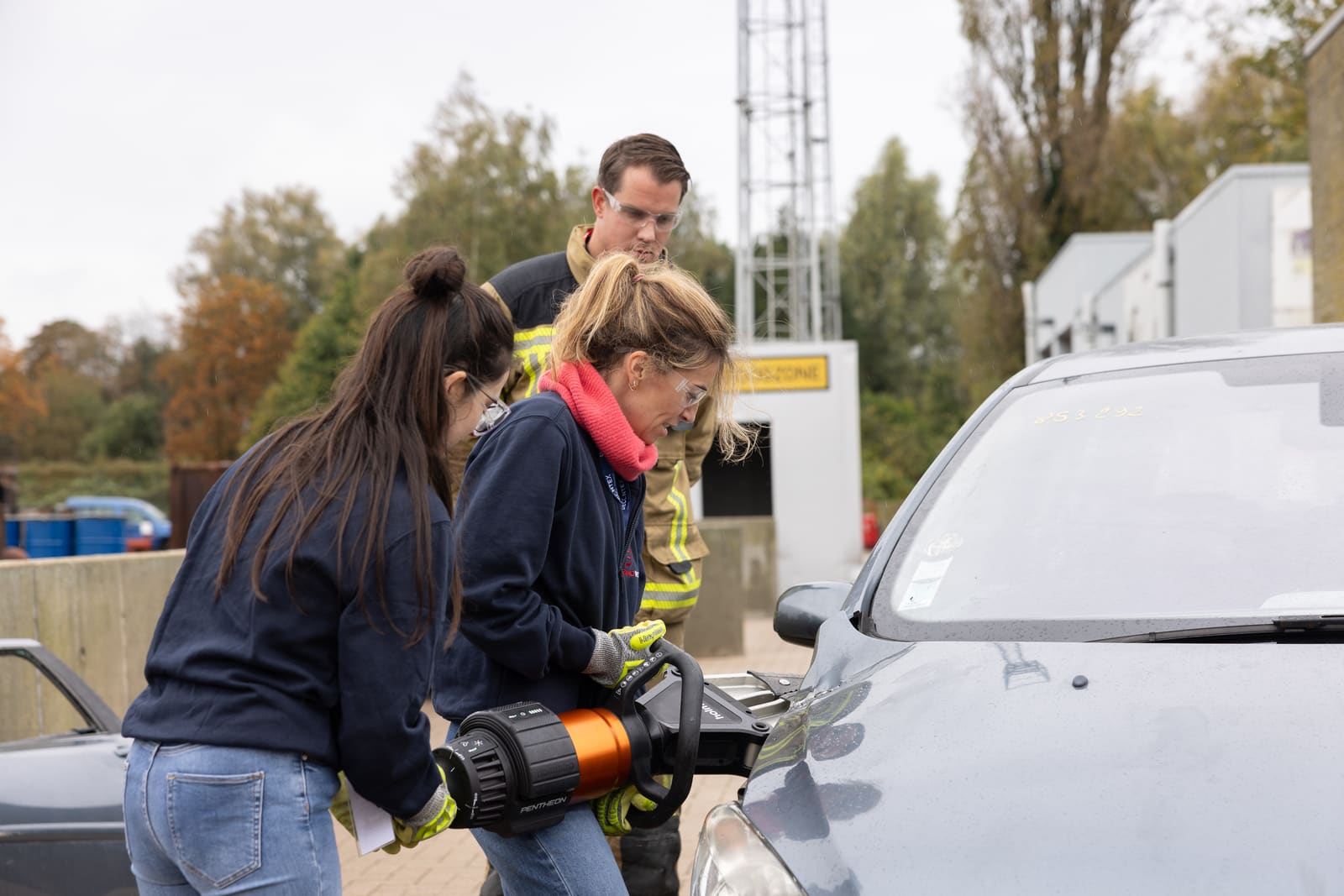 Deelnemers bedienen een hydraulisch redgereedschap op een oefenwagen
