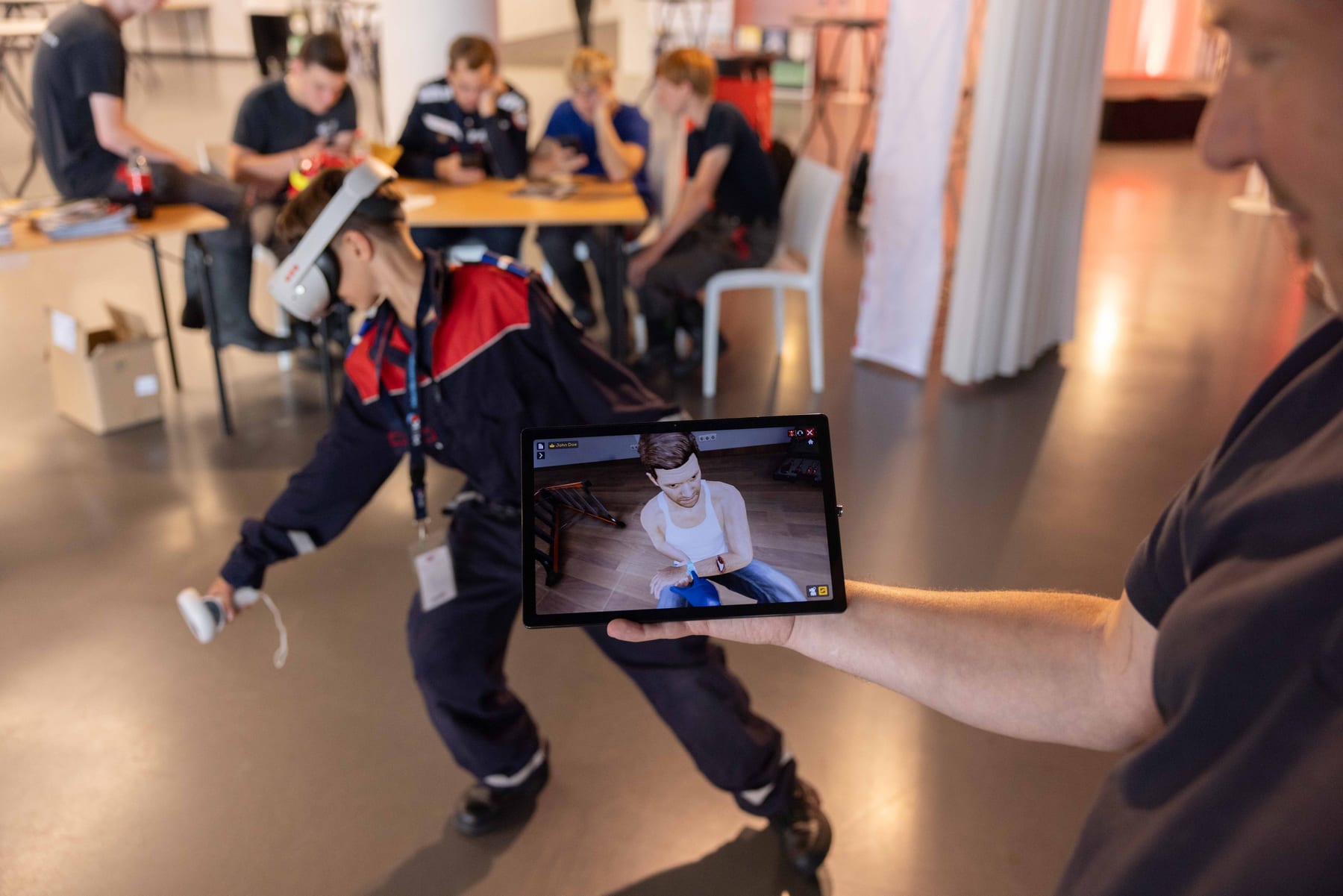 Jeugdbrandweerlid oefent met een VR-bril terwijl een instructeur de simulatie op een tablet volgt