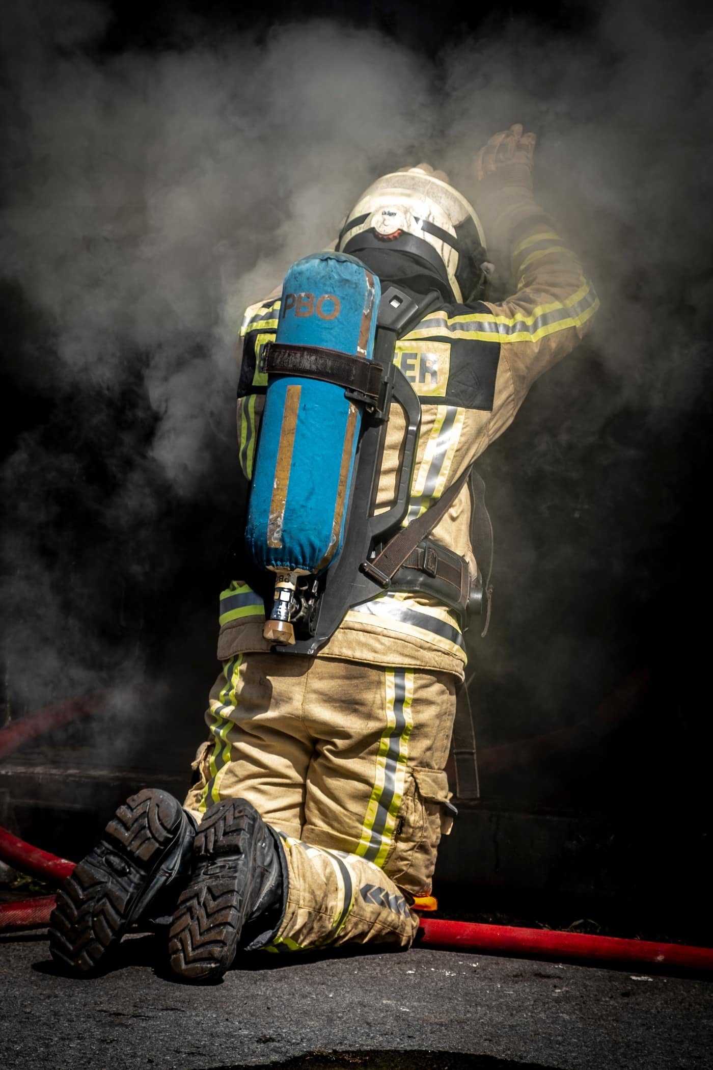 Brandweerman knielt in de rook tijdens een oefening